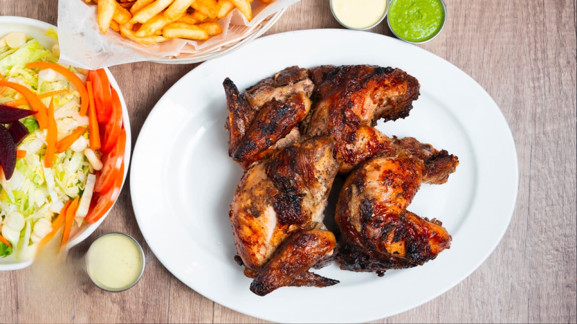 Pollo a la Brasa — Taty's signature Peruvian charcoal rotisserie chicken on a platter
