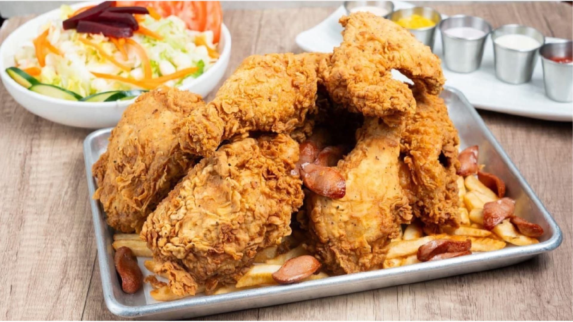 Family feast with crispy Peruvian broaster fried chicken pieces on a tray