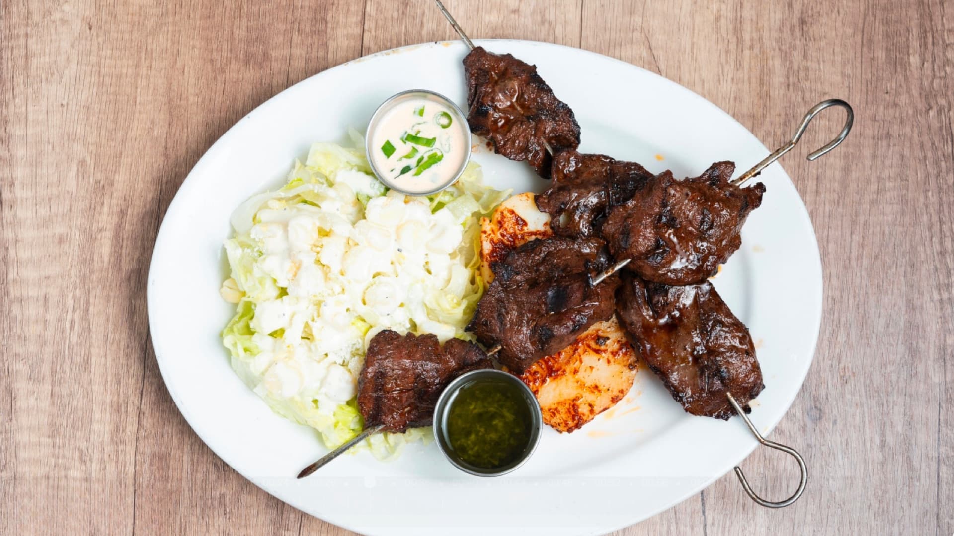 Anticuchos — marinated beef heart skewers served with Peruvian corn and potatoes